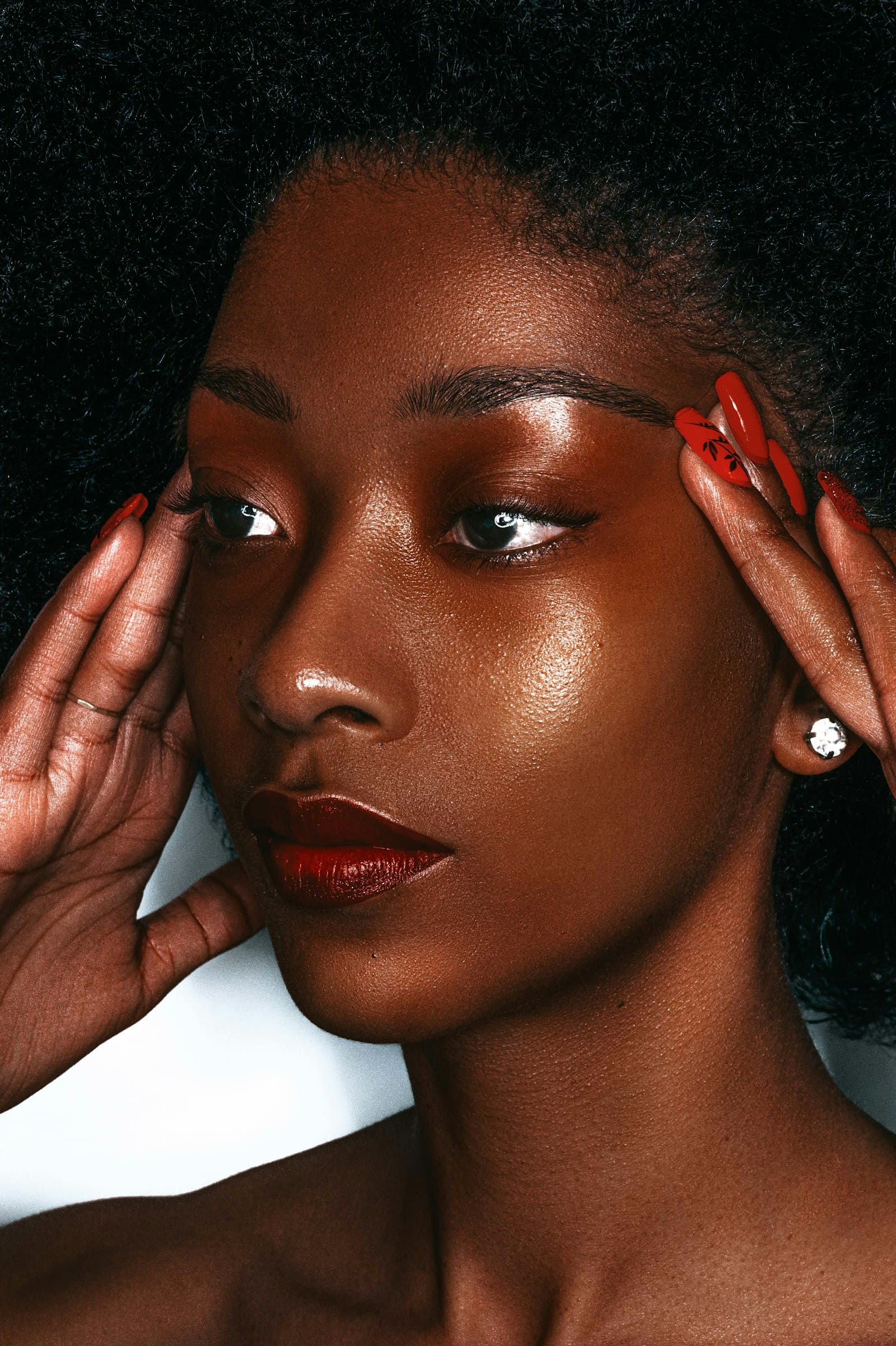 A woman with a striking red manicure framing her face