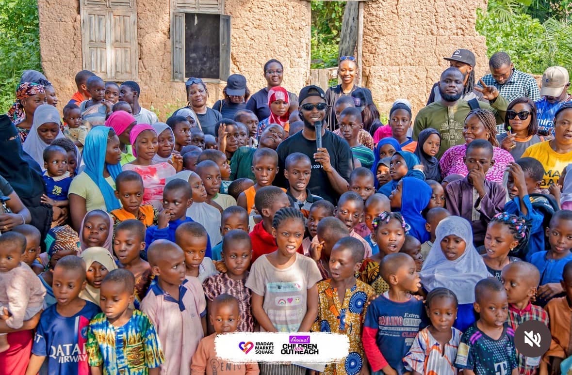 Children and volunteers smiling through the IbadanMarketSquare photo frame at the outreach