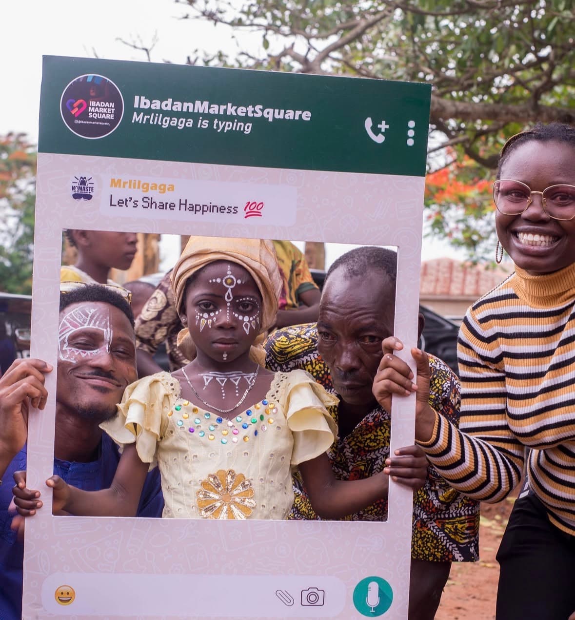 Children and volunteers smiling through the IbadanMarketSquare photo frame at the outreach